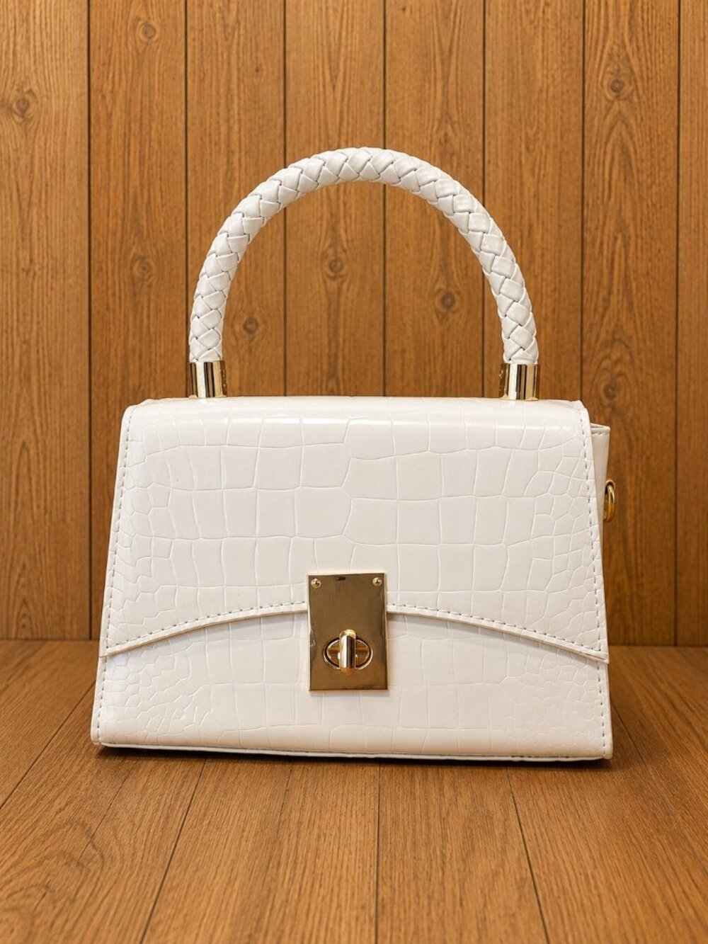White crocodile-textured structured handbag featuring a braided top handle